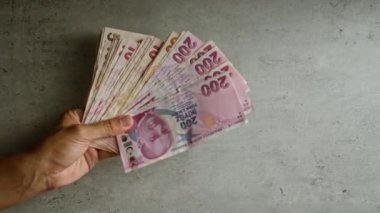 Elde tutulan Türk lira banknotları somut bir arka plan, sergilenen para, finans ve ekonomi Türkiye 'de para yönetimi ve mali tasarruflara odaklı.