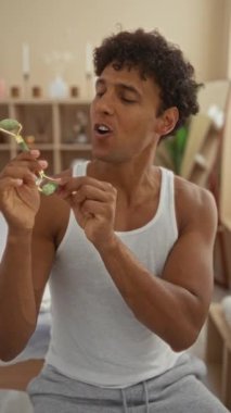 Kaplıcada eğlenirken yüz silindiri kullanan genç bir adam.