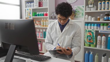 Eczanede beyaz laboratuvar önlüğü giyen yakışıklı, genç bir İspanyol adam bilgisayarın arkasında çeşitli ürünlerle çevrili bir şekilde dikilirken bir panoya özenle yazı yazıyor..