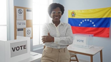 Venezuela bayrağıyla süslenmiş bir seçim koleji odasında güven içinde duran kadın, oy verme haklarının ve vatandaşların katılımının önemini vurguluyor..