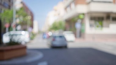 Güneşli bir şehirde arabaların ve binaların olduğu bir şehir manzarasının bulanık arkaplanı