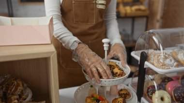 Fırında eldiven ve kahverengi önlükle yemek hazırlayan bir kadın, çeşitli hamur işleri ve tatlılar sergiliyor..