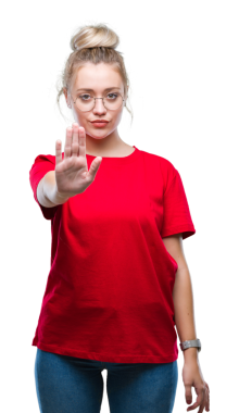 Genç sarışın beyaz kadın şeffaf arka planda dur hareketi yapıyor.