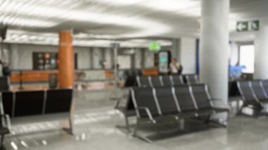 Boş koltukları olan bulanık havaalanı ayarları, çözülmüş gezginler ve modern bekleme salonunda bokeh ışıklandırması.
