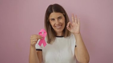 Genç İspanyol kadın gülümsüyor ve el kol hareketi yapıyor. Pembe kurdeleli, arkadaş canlısı ve kendinden emin.