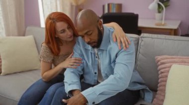 Kadın, erkeği oturma odasındaki koltukta rahatlatıyor. Sıcak bir evde sevgi ve empati sergiliyor..