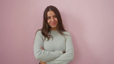 Kolları çapraz pembe bir duvara yaslanmış güvenle gülümseyen bir kadın basit ama büyüleyici bir portrede güzelliğini ve çekiciliğini sergiliyor..