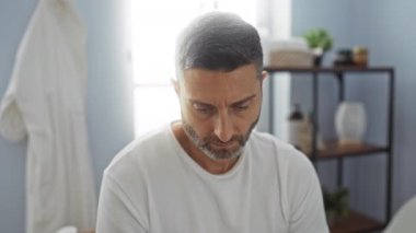 Modern iç tasarıma sahip spa ortamında dinlenen bir adam, sakin bir atmosfer ve minimalist dekor ve doğal ışık da dahil olmak üzere refah odağı sergiliyor.