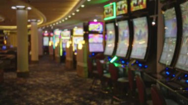 Las Vegas 'ta hareketli bir kumarhane zemininde renkli kumar makineleri, parlak ışıklar ve canlı halılar ve ortam aydınlatmasıyla güçlendirilmiş davetkar bir atmosfer..