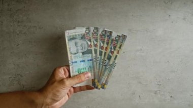 Beton bir duvarın önünde el ele tutuşan Peru tabanları görünür detaylarla para gösteriliyor..