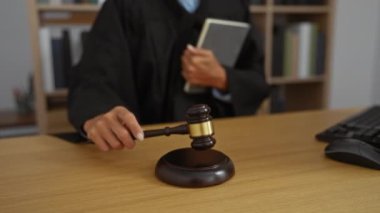 Elinde tokmak tutan kadın yargıç mahkeme salonunda bir karar vermeye hazırlanıyor.