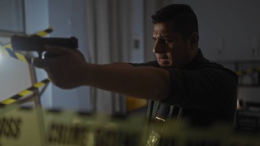 Karanlık bir kapalı mekan suç mahallinde silahlı ve rozetli İspanyol bir adam.