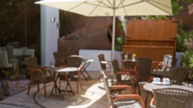 Lanzarote 'de bulanık bir açık hava kafesi hasır sandalyeli, masalı, büyük şemsiyeli ve yeşillikli İspanya kanarya adalarında sönük, rahatlatıcı bir ortam yaratıyor.