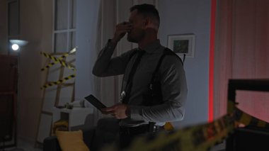 Evdeki suç mahallinde sıkıntılı bir adam, elinde bant, sıkıntılı, elinde kanıt ve el feneri olan, karanlık bir dairede..