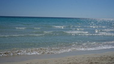 Stunning seascape in porto cesareo, italy, showcasing the tranquil, clear waters and sandy beach under a bright, blue sky in the beautiful salento region of puglia. clipart