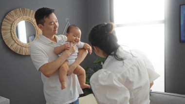 Aile, şık bir apartman dairesinde birlikte vakit geçiriyor. Baba, bebek ve anneyi kucaklıyor. Sıcak ve sevgi dolu bir ortam yaratıyor..