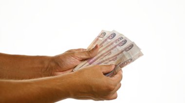 Finansal değişim veya ödeme kavramını gösteren izole edilmiş beyaz bir arkaplan üzerinde Rus rublesi tutan eller.