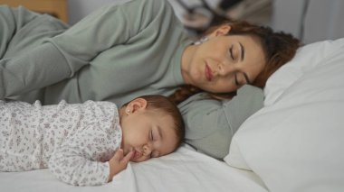 Mother and baby sleeping peacefully together in a cozy bedroom, capturing the essence of family love and intimate bonding during a serene indoor moment. clipart