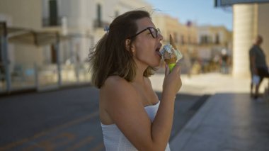 Gelibolu, puglia, İtalya sokaklarında dondurma yiyen genç İspanyol kadın..
