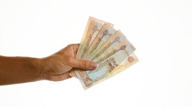 Beyaz arkaplan üzerinde birden fazla uae dirhem tutmak birleşik Arap emirliklerinde finansal konsepti göstermektedir.