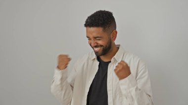Sakallı neşeli bir siyah adam izole edilmiş beyaz bir arka planda kutlama yapıyor.