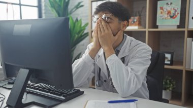 Medikal kıyafetli stresli genç bir Arap, klinikteki çalışma yerinde patlak verdi..