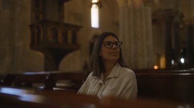 İtalyan kilisesinde oturan genç İspanyol kadın, dingin bir Hıristiyan ortamında mimari güzelliği düşünüyor..