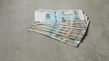 Peru 'nun beton yüzeyinde duran 100 sol' luk Peru banknotları, Peru 'da genellikle finansal ve parasal bağlamlarda kullanılan yığınla para birimini yakalıyor..