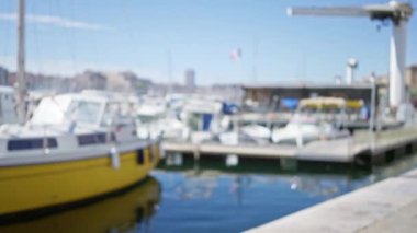 Fransa 'daki Marsilya limanının bulanık teknelerinin ve güneşli mavi gökyüzünün Bokeh etkisi ile sakin deniz kenarı atmosferini vurguluyor..