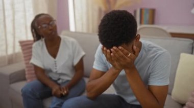 Bir kadın onunla oturma odasında konuşurken, bir anne ve oğlunun evde aile meselelerini tartıştıklarını gösteren bir adam kendini üzgün hisseder.