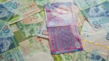 Renkli Hong Kong dolar banknotları, öne çıkan aslan motifleri ve dağınık bir düzende sıralanmış çeşitli mezhepler.
