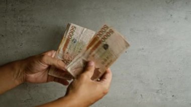 Kore 'nin kazandığı paraları somut bir zemine karşı sayan eller.