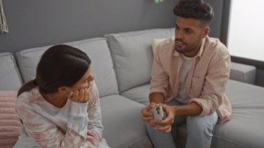 Çift, evde birlikte oturur kadın, erkeğin ev ortamında konuşmasını dinler. Oturma odası rahat bir ortam yaratır.