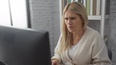 Ofis ortamında hayal kırıklığını ifade eden bir kadın. Etrafı bilgisayar ve kitaplarla çevrili. Masasında iş stresiyle karşılaşan bir kadın..