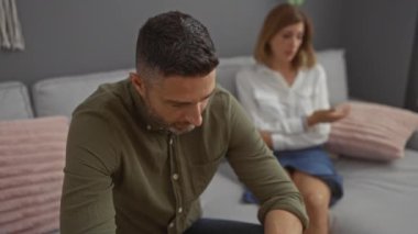 Oturma odasındaki kanepede oturan erkek ve kadın, mutsuz ve ciddi bir konuşmanın ortasında.