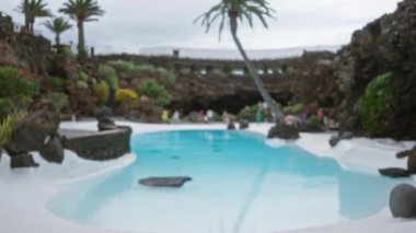 Lanzarote 'daki bir havuzun bulanık görüntüsü. Geçmişi bulanık ve çevresindeki insanlar bulanık.