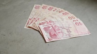 Türkiye 'nin 10 liradan oluşan banknotları düz bir beton yüzeye yayılarak para birimi ayrıntılarını vurguluyor.