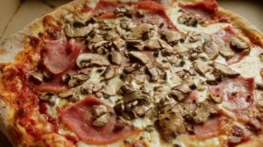 Lezzetli mantar ve jambonlu pizza karton bir kutuda malzemeler ve erimiş peynir.