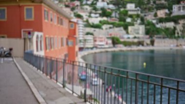 Villefranche-sur-mer 'deki bulanık kıyı manzarası, açık gökyüzünün altında manzaralı binaların olduğu Fransa, canlı renkler ve sakin bir atmosfer..