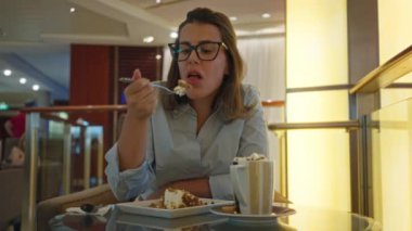 Lüks bir bar ortamında tatlıyı seven bir kadın şık bir iç mekan ve rahat bir ortam sunuyor. Lüks bir ev ortamında sofistike ve konforu yansıtıyor..