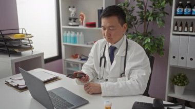 Klinikteki doktor, bilgisayarlı ve steteskoplu telefonla konuşuyor. Profesyonel kapalı mekan ortamında sağlık hizmeti sunuyor.