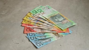 Avustralya 'nın çeşitli banknotları, parasal zenginlik ve finansal güvenliği temsil eden somut bir yüzeye saçıldı.