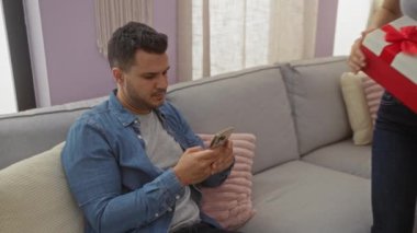 Kadın ve erkek, sıcak bir salonda aynı hediyeyi paylaşıyor. Kapalı alanlarda sevgi, neşe ve beraberlik sergiliyorlar..