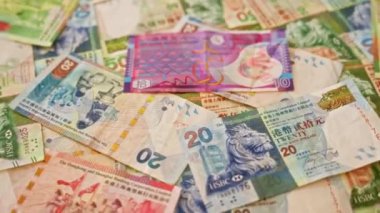 Düz zemine saçılmış renkli Hong Kong doları banknotları Hong Kong 'un canlı ekonomisini ve finansal çeşitliliğini yansıtıyor.