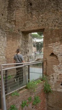 Roma forumunda tarihi kalıntıların arasında yürüyen kadın Roma, İtalya 'da doğa ve tarihin karışımını sergiliyor..