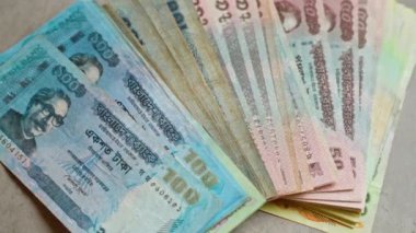 Çeşitli banknotların banknotları somut bir yüzeye yayılarak yerel para birimi ve ekonomik kültürü gözler önüne seriyor.