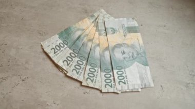 Endonezya 2000 rupia banknotları döviz ve finans detaylarını vurgulayan somut bir yüzeye saçıldı