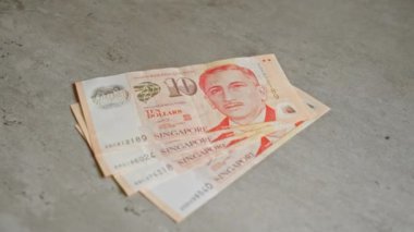 Singapur banknotları beton bir yüzeye yerleştirilmiş 10 dolarlık banknotlar gösteriyor..