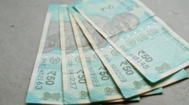 Hindistan 'da finansal para birimini gösteren beton bir yüzey üzerinde hayran şeklinde düzenlenmiş Hint rupi banknotları..