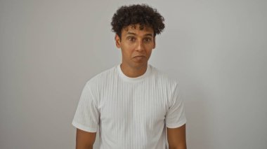 Beyaz arka planda izole edilmiş genç İspanyol adam kameraya bakıyor.